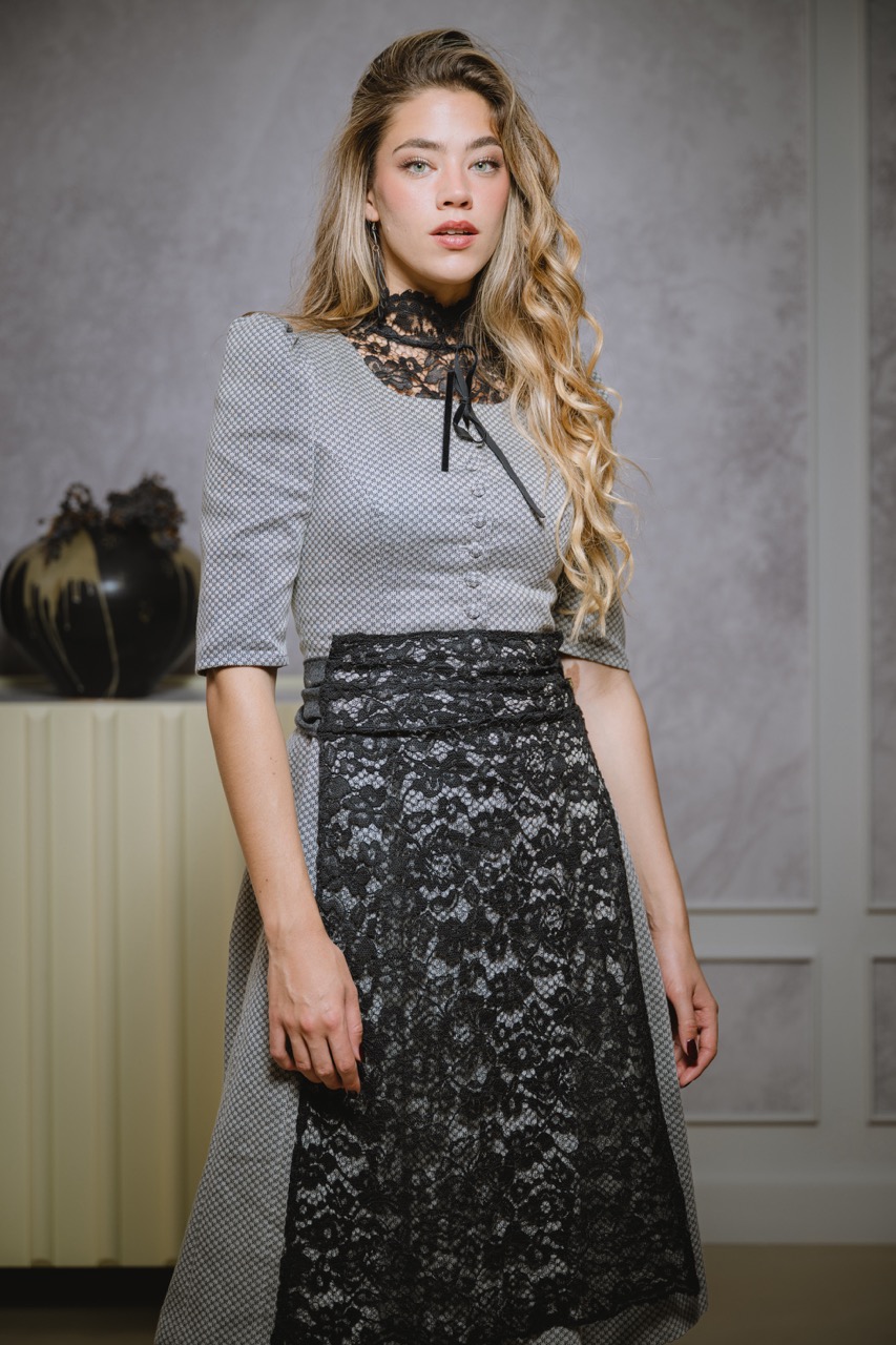 Junge Frau in elegantem schwarz-grauem Dirndl mit Spitzenschürze