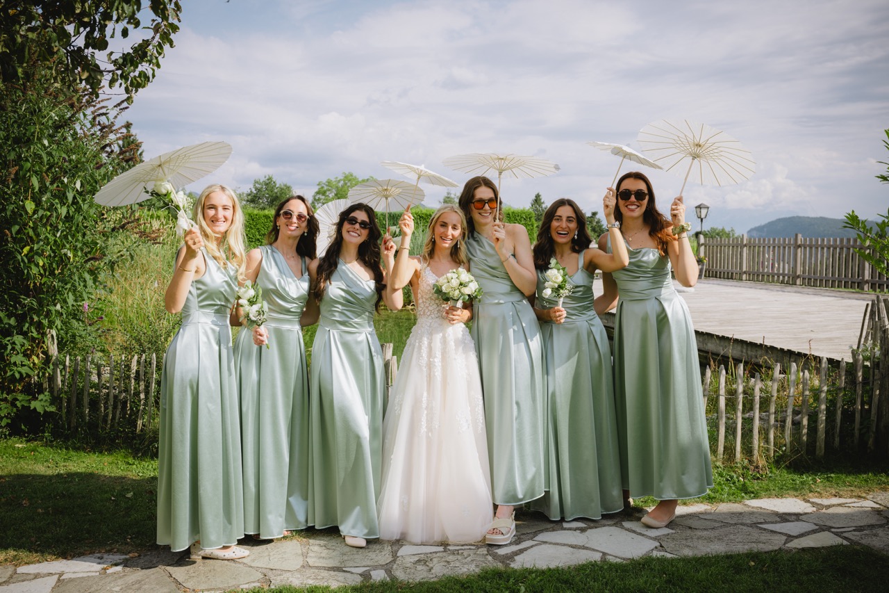 Braut posiert mit Brautjungfern in mintgrünen Kleidern und Sonnenschirmen